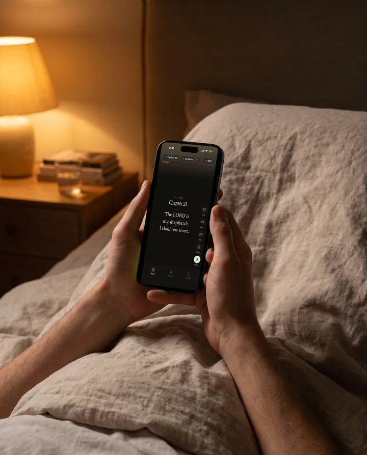 Reading Sacred Feed in dark mode in bed by lamplight.
